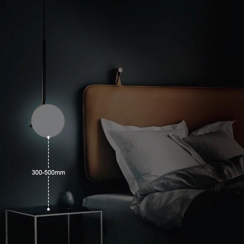 Đèn ngủ tối giản treo cạnh giường với ánh sáng dịu, tạo không gian thư giãn. Kích thước cách bàn 300-500mm.