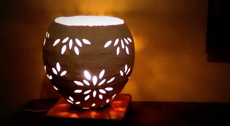Đèn gốm nghệ thuật với hoa văn ánh sáng, tạo ra không gian ấm cúng và thư giãn trong căn phòng.