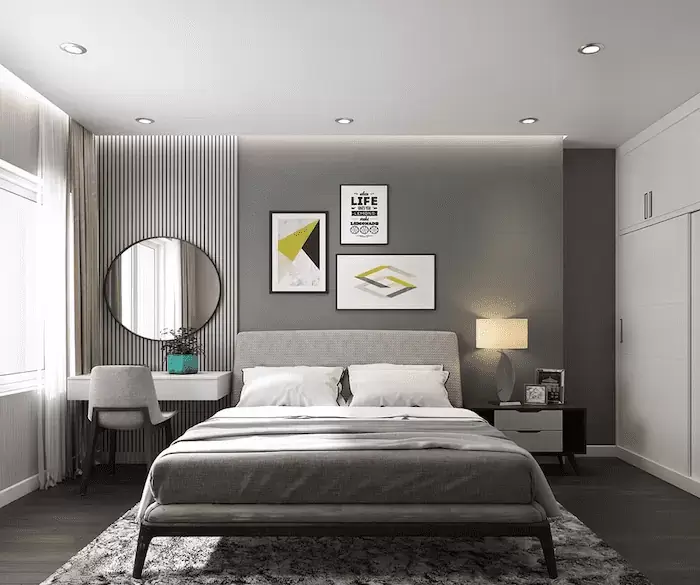 Phòng ngủ hiện đại với giường xám, tranh treo tường trang trí và bàn trang điểm, ánh sáng ấm áp và phong cách tinh tế.
