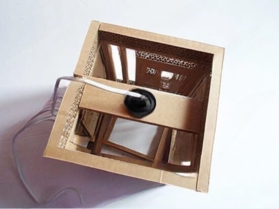 Hộp loa tự chế từ bìa carton tái chế, có dây kết nối, góc nhìn từ trên xuống, sáng tạo và thân thiện với môi trường.