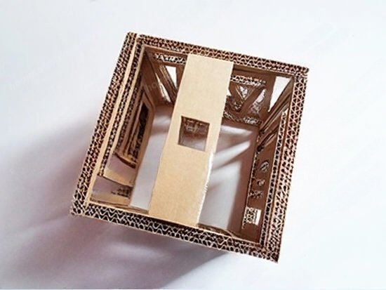 Mô hình kiến trúc Eiffel bằng bìa cứng với chi tiết phức tạp, nhìn từ trên xuống dưới góc nhìn toàn cảnh.
