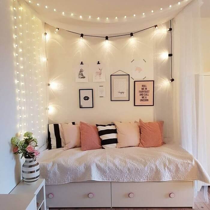Giường nhỏ xinh trang trí đèn nhấp nháy, gối họa tiết hiện đại, tường treo tranh phong cách tối giản.
