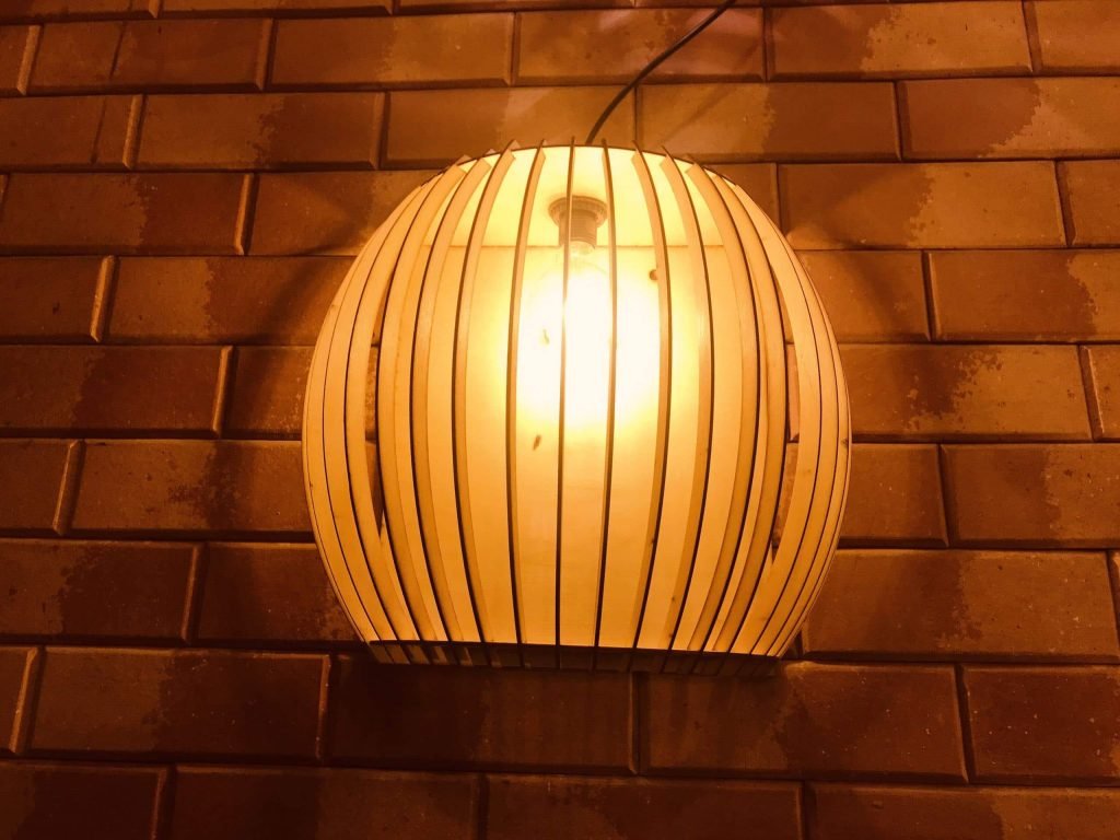 Ý tưởng, Cách làm đèn ngủ bằng gỗ trang trí tuyệt đẹp 15 Đèn treo tường hình cầu bằng gỗ độc đáo, tỏa sáng ấm áp lên bức tường gạch nâu, tạo không gian ấm cúng và sang trọng.